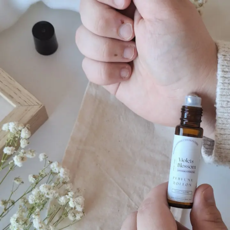 Mujer aplicando perfume natural de lavanda y violetas
